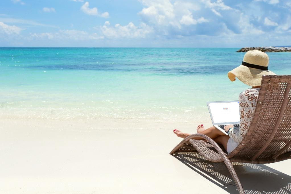 image of a beach with person viewing laptop